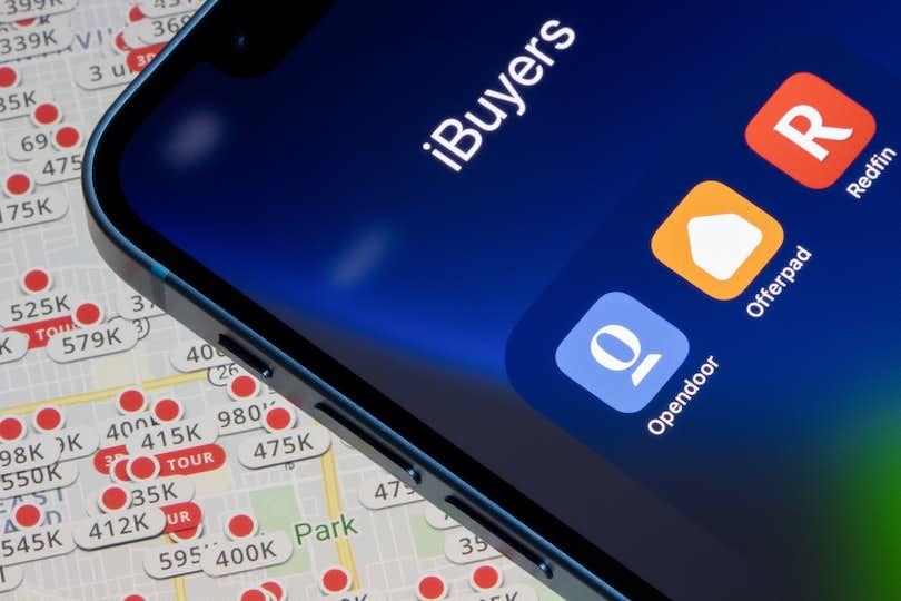 Image of phone showing iBuying apps in front of Zillow listings