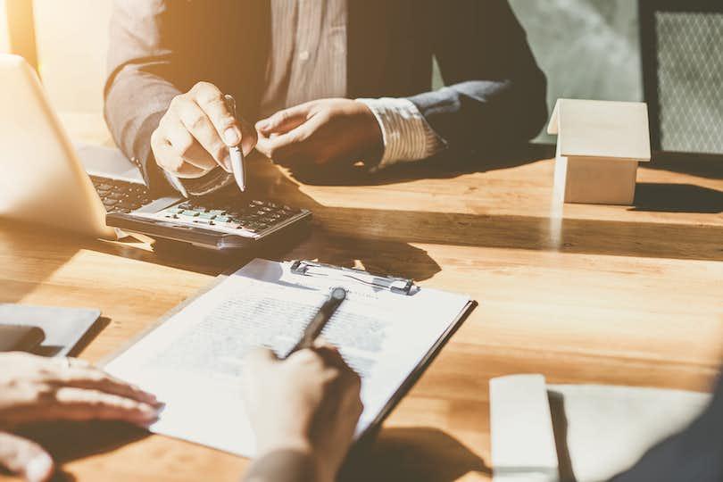 People at desk working on a contract.